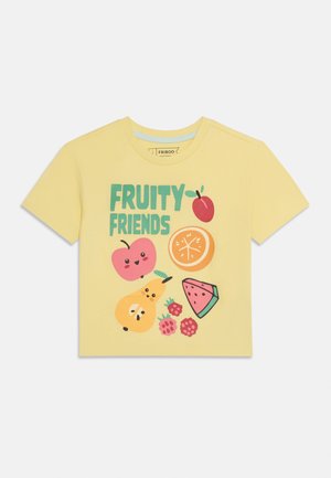 Camiseta amarilla de manga corta con el texto "AMIGOS FRUTALES" y personajes de frutas en dibujos animados que incluyen manzana, rodaja de naranja, pera, sandía y frambuesas.