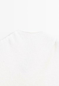 Hvid strikket sweater med rund halsudskæring og subtil tekstur. Stoffet er blødt, med en let løstsiddende pasform og uden synlige mønstre.