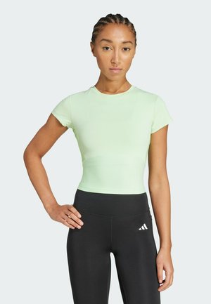 Vihreä, sovitettu urheilupaita, jossa on lyhyet hihat ja ribbikuvio, yhdistettynä korkeavyötäröisiin mustiin legginsseihin, joissa on logo.