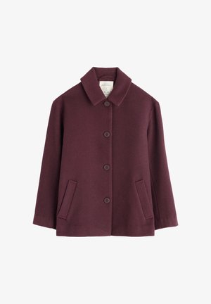 Bordo kaput s teksturiranim završetkom, s istaknutim ovratnikom, šest dugmadi i dva bočna džepa. Srednje dužine i ravnog kroja.