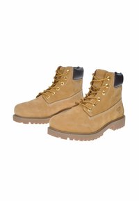 Stivaletti alla caviglia in suede tan con accenti in pelle marrone, occhielli dorati e suola in gomma. Presentano una superficie testurizzata e un colletto imbottito.