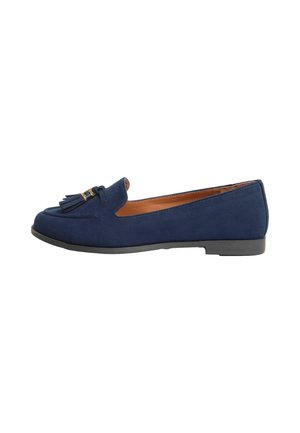 Mocassins en suede bleu marine avec un bout arrondi, un pompon décoratif et un accent métallique, dotés d'une semelle en caoutchouc plate et d'une doublure en cuir lisse.