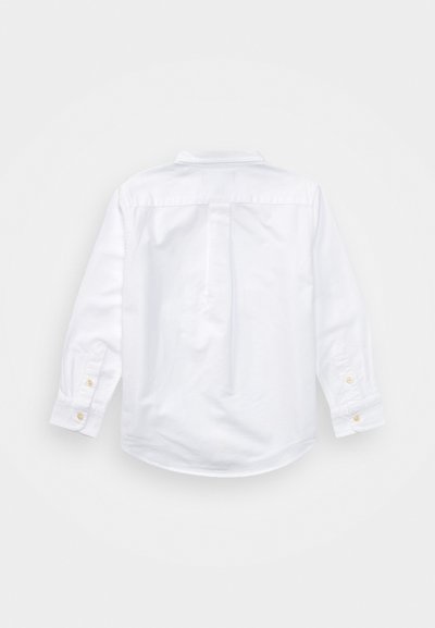 Chemise blanche à manches longues boutonnée, vue de dos avec un pli unique au dos et des poignets boutonnés.