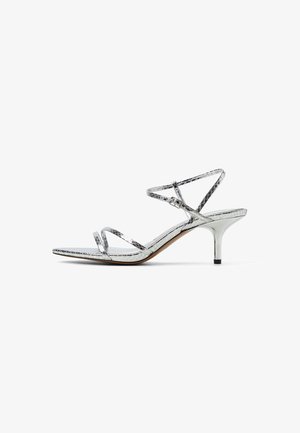 Silver strappy high-heeled sandals with a metallic finish, featuring a slender ankle strap and a pointed toe design.