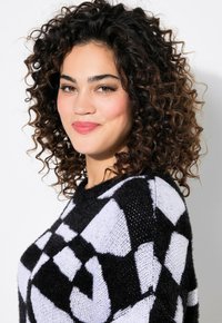 Maglione a righe bianco e nero con scollatura rotonda e tessuto testurizzato, caratterizzato da un design geometrico e una consistenza morbida e pelosa.