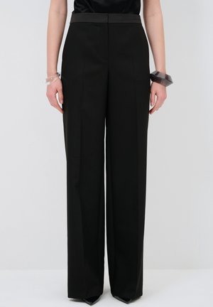 Black wide-leg trousers with a high waistband, crafted from smooth fabric. Features sharp crease lines and a tailored silhouette.