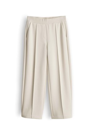 Pantalon beige à jambes larges avec taille élastique et poches latérales, avec des plis devant et une coupe ample et décontractée.