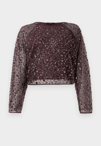 Bordeaux kleurige cropped trui met lange, doorzichtige mouwen, versierd met verspreide pailletten en kralen voor textuur en visuele interesse.