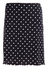 Jupe noire à pois blancs, fabriquée en tissu doux, avec un ourlet en forme de vagues et une silhouette ajustée.