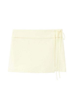 Mini-jupe portefeuille couleur crème avec fines attaches latérales et un design lisse et minimaliste.