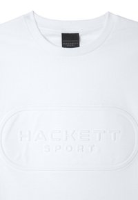Hvid bomulds t-shirt med rund hals og et forhøjet, præget logo "HACKETT SPORT" i midten. Glat tekstur, enkelt design.
