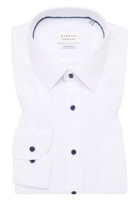 Camisa blanca de vestir con cuello rígido, botones azul marino y un único bolsillo en el pecho. Textura suave con un diseño de ajuste cómodo. Etiqueta Eterna.