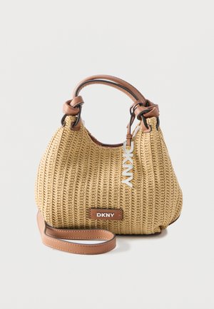 Béžová tkaná kabelka s koženými rúčkami a remienkom, zdobená plaketou s logom DKNY a visiacimi kovovými písmenami DKNY.