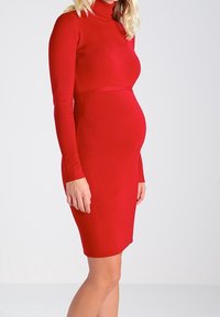 Rotes, geripptes, langärmeliges Kleid mit taillierter Silhouette, hochschließendem Kragen und enganliegendem Taillenbereich, speziell für die Schwangerschaft entworfen.