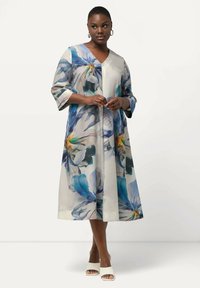 Vestido midi floral con tonos azules y blancos, escote en V, mangas tres cuartos y una silueta fluida. Textura suave con patrones de hojas.