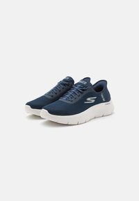 Navy blue mesh sneakers with white soles, round toe, and lace-up design. Features textured sides and logo accents on the tongue and heel.