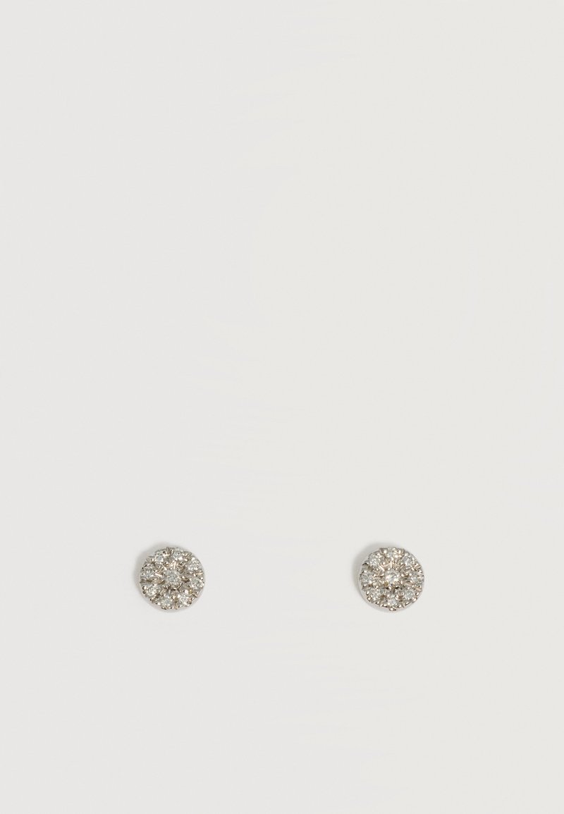 Boucles d'oreilles clous rondes en argent avec plusieurs petites pierres transparentes étincelantes disposées en motif floral en grappe sur un fond blanc uni.