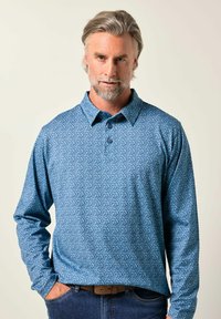 Pánská polokošile s dlouhými rukávy ve světle modré barvě se jemným vzorem; tříknoflíková léga a klasický límec; v kombinaci s tmavými džíny.