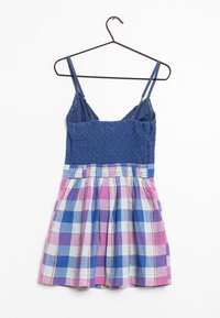 Klänning med spagettiband och en smockad blå bodice. Den utsvängda kjolen har ett flerfärgat rutmönster i rosa, blått och ljusblått.