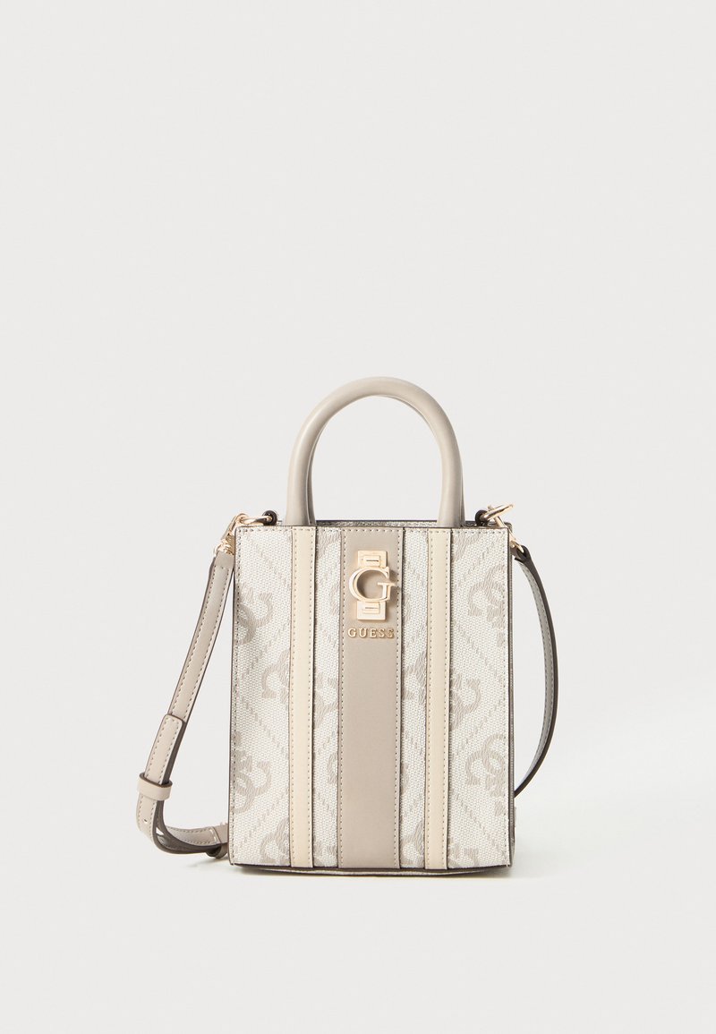 Kompakt beige og creme Guess håndtaske med top-håndtag, aftagelig skulderrem og gyldent logo-plade på mønstret stof.