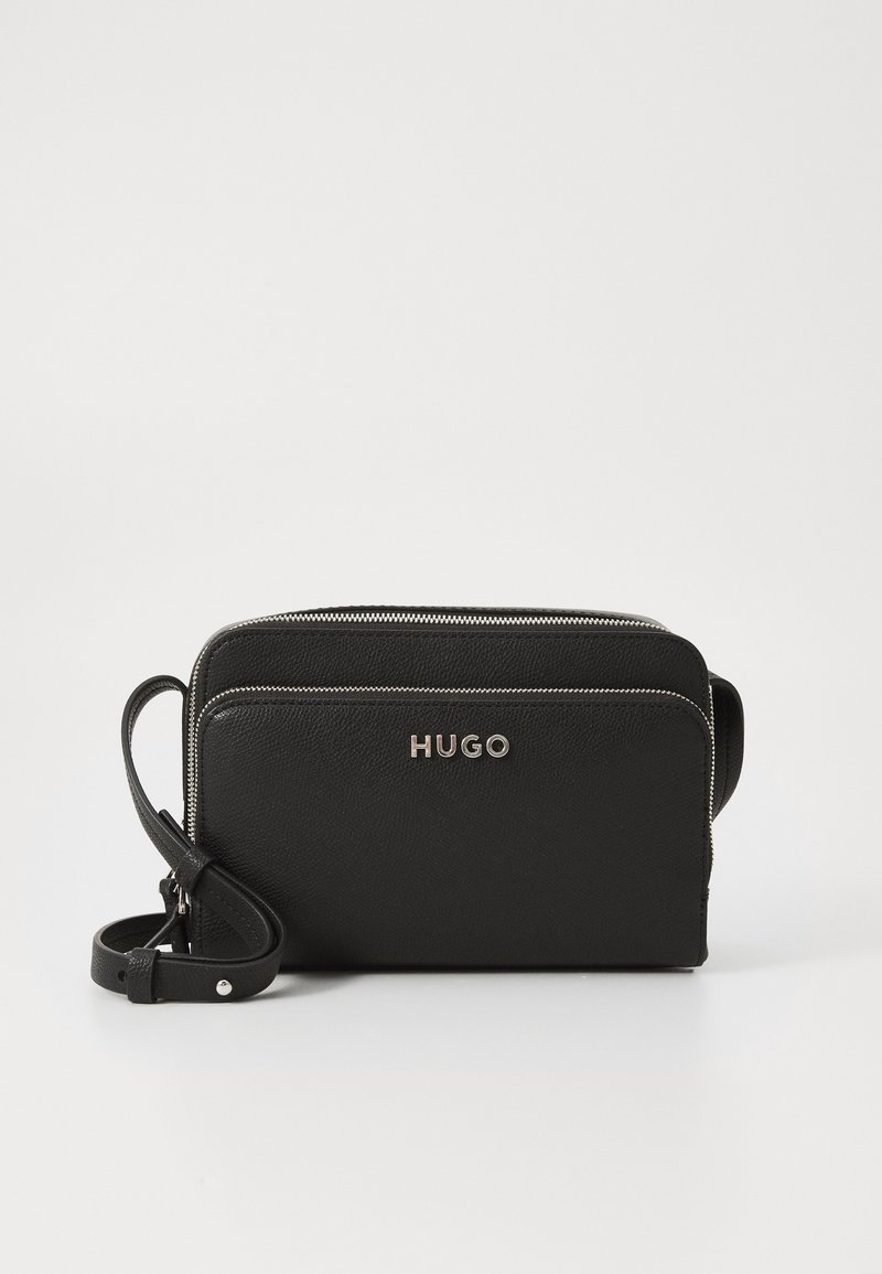 Black leather crossbody bag with two zippered compartments, embossed logo, and an adjustable strap. Features a textured finish.