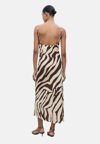 Robe à imprimé zèbre marron et crème avec de fines bretelles, dos cintré, silhouette fluide et fente sur le côté, fabriquée en tissu doux.