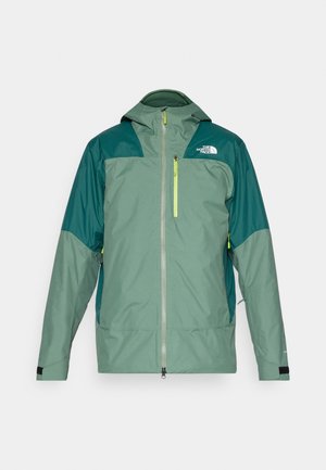 Chaqueta impermeable verde con cremallera frontal, capucha, paneles de hombros en verde oscuro y un bolsillo con cremallera reflectante amarillo.