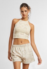 Beige katteliku tooni halterneck top koos mustrilise disainiga, sobitatud laia lõikega lühikeste pükstega, millel on tekstuuriga viimistlus ja elastne vöökoht.