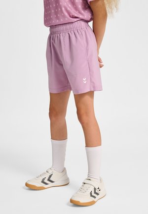 Ljuslila shorts i mjukt tyg med elastisk midja, prydda med vita chevron-logotyper på nedre vänstra sidan. Matchas med vita strumpor och sneakers.