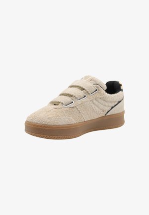 Baskets en textile beige avec fermeture velcro, semelle en caoutchouc gomme, surface texturée et subtil accent noir le long du bord.