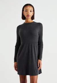 Robe tricotée gris foncé avec une texture côtelée, des manches longues, un corsage ajusté et une jupe évasée. Encolure ras du cou avec un design sans coutures.