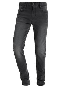 Jeans de denim negro con un ajuste slim, diseño de cinco bolsillos, cierre de cremallera y trabillas para cinturón. Presentan una ligera textura desgastada.