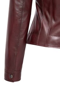 Giacca di pelle bordeaux con un design aderente, texture liscia e cuciture dettagliate, con un bottone a scatto sul polsino.