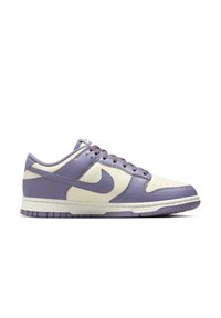 Basket basse Nike en cuir crème et violet clair avec des lacets violets et une semelle intermédiaire blanche mouchetée, vue de côté.