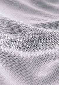 Light gray fabric with a subtle grid pattern in darker gray. Smooth texture with soft drapery, featuring fine, evenly spaced lines.