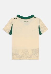 Camicetta cream a maniche corte con colletto e maniche verdi, caratterizzata da un motivo floreale all'orlo inferiore. Logo verde sul retro.