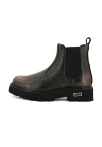 Brązowy skórzany butChelsea z elastycznymi panelami bocznymi, pętlą do zakładania oraz grubą czarną podeszwą z teksturowanym wzorem.