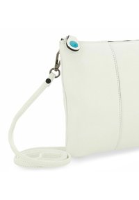 Borsa a tracolla bianca in pelle con texture liscia, caratterizzata da un bottone di accento blu e una tracolla rimovibile. Chiusura con zip nella parte superiore.