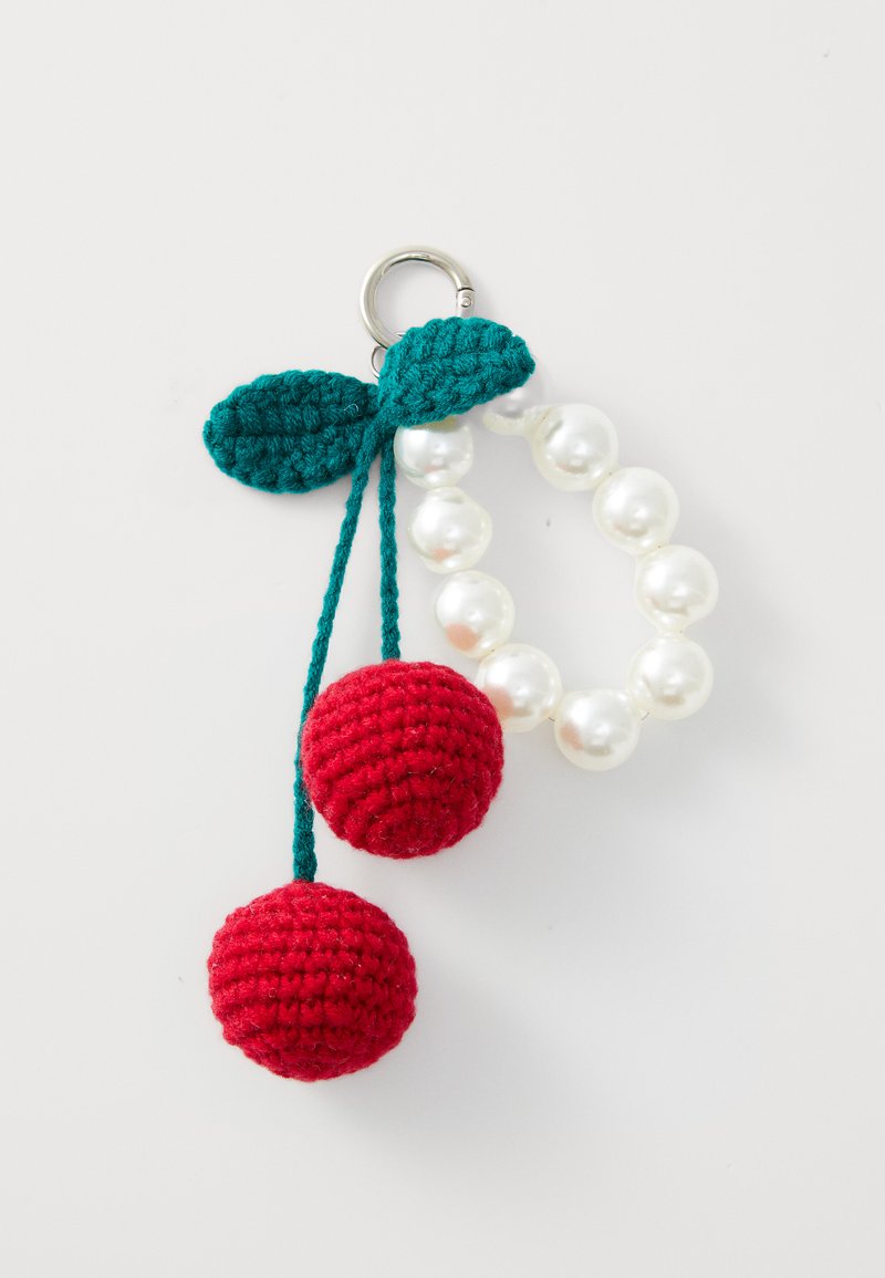 Kersvormige sleutelhanger met rode gehaakte ballen, groene bladeren en een parelketting. Voorzien van een zilveren metalen sleutelring.