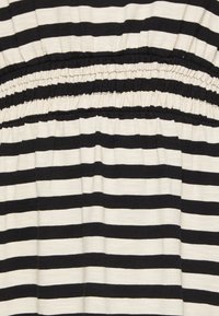 Mustekala ja kreemivärvi triibuline kangas, millel on kokku kokkutõmmatud vöökoht, featuring ühtlased horisontaalsed jooned pehme ja veniva tekstuuriga.