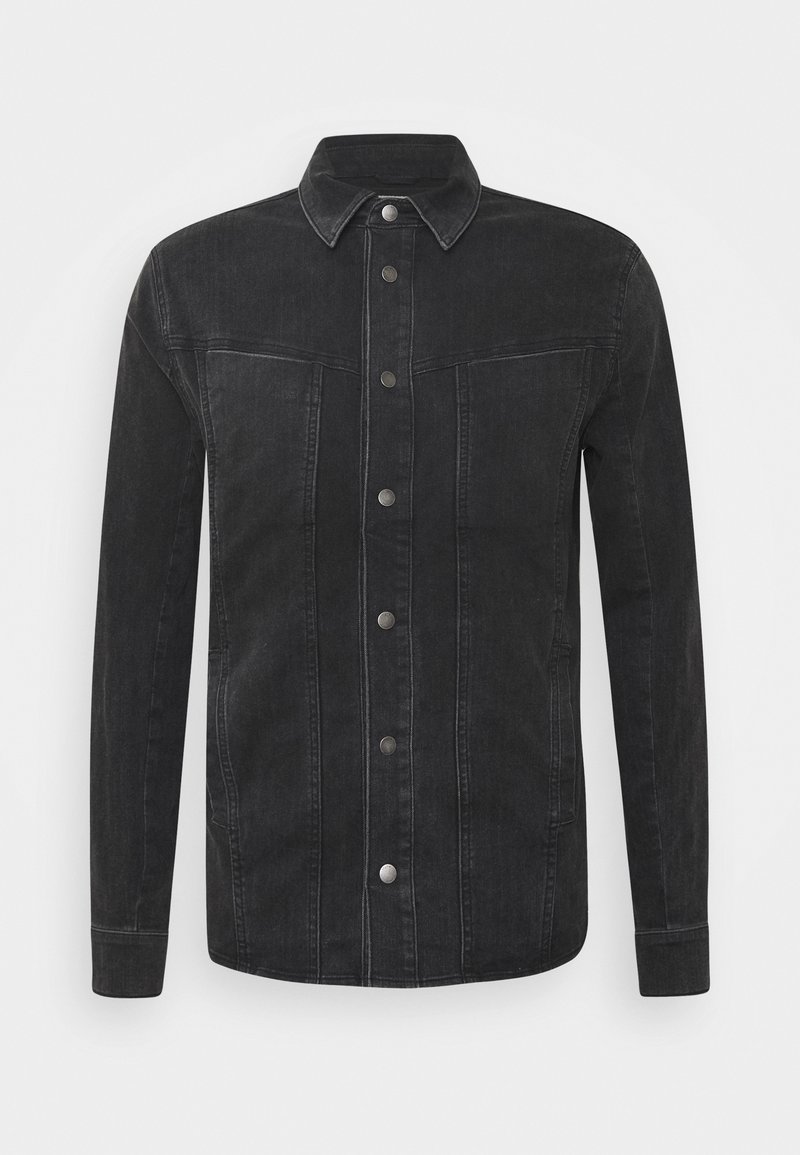 Svart denimjacka med spetsig krage, knappstängning framtill, två bröstfickor och sidofickor med synliga sömmar och detaljer.