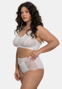 Bralette en dentelle blanche et culottes taille haute. Le bralette présente des bonnets doux et un nœud décoratif au centre ; les culottes ont des accents en dentelle sur les côtés.