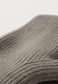 Tissu en laine gris côtelé avec une texture douce et des variations subtiles. Le motif présente des sections surélevées uniformément espacées.