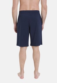 Shorts bleu marine, longueur genou, en tissu doux avec une taille élastique et des poches latérales, vus de l'arrière.