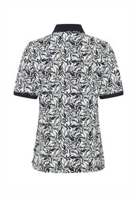 Polo à manches courtes avec motif de feuilles noires sur fond blanc, col noir et poignets noirs, vu de dos.