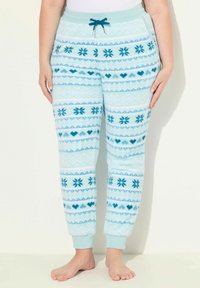 Svetle modré fleecové tepláky s opakujícím se vzorem sněhových vloček, srdcí a diamantů v tmavší modré barvě, s elastickým pasem a manžetami.