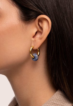 Boucles d'oreilles en or en forme de créole avec un accent sphérique marbré bleu, mettant en valeur une texture lisse et une finition polie.