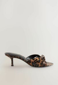 Valkoiset korot mules-leopardikuosisilla, kiiltävällä pinnalla, avoimella varpaalla, ristikkäisellä hihnadesignilla ja pyöreällä koristet yksityiskohdalla päällä.