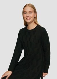 Schwarzer Strickpullover mit einem strukturierten Muster aus offenen Rauten, Rundhalsausschnitt und gerippten Bündchen. Weicher, mittelschwerer Stoff.