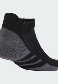 Calcetín deportivo negro y gris de corte bajo, con textura acanalada, talón reforzado y tres franjas horizontales para mayor agarre.